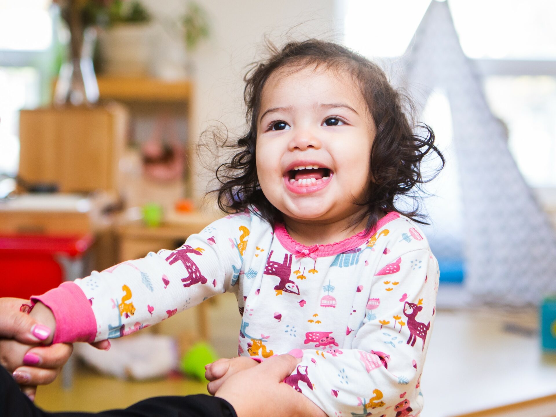 Toddler smiling in a classroom